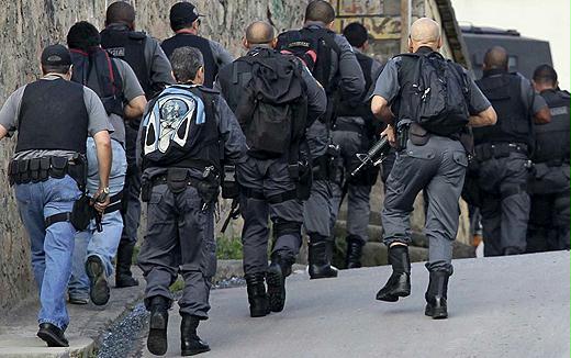 Com o apoio de tropas federais, compostas de fuzileiros navais pára-quedistas, as polícias civil e militar tomam militarmente o Complexo do Alemão, assim como ocuparam antes a Vila Cruzeiro. Simultaneamente ao avanço das forças estatais, pode ser dar a projeção ainda maior das forças para-estatais, conhecidas como milícias, se nada for feito para deter esta máfia. No meio do espetáculo midiático, avança a criminalização do protesto social.  - Foto:efe