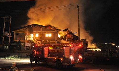 A ira dos operários da Arena da OAS-Grêmio levou ao incêndio do alojamento onde estes homens brasileiros eram confinados, em isolamento na entrada da capital rio-grandense.  - Foto:esportes.opovo.com.br