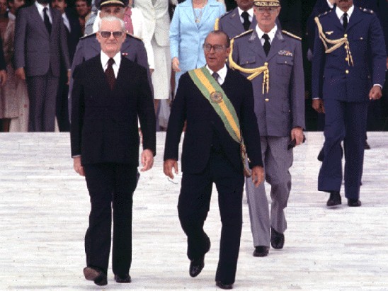 João Batista de Oliveira Figueiredo recebe a faixa de general-presidente das mãos de Ernesto Geisel, um dos operadores da Anistia, para felicidade dos torturadores e aqueles que os apoiavam, dentro e fora do aparelho de Estado. Depois da decisão do STF, houve festa à fantasia verde oliva de pijama no inferno.  - Foto:sti.br